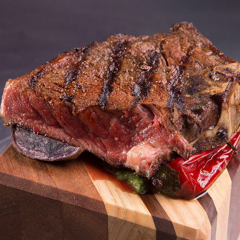 Bone-in Strip with Roasted Fingerling Potatoes, Fried Shishito Peppers, and Peruvian aji